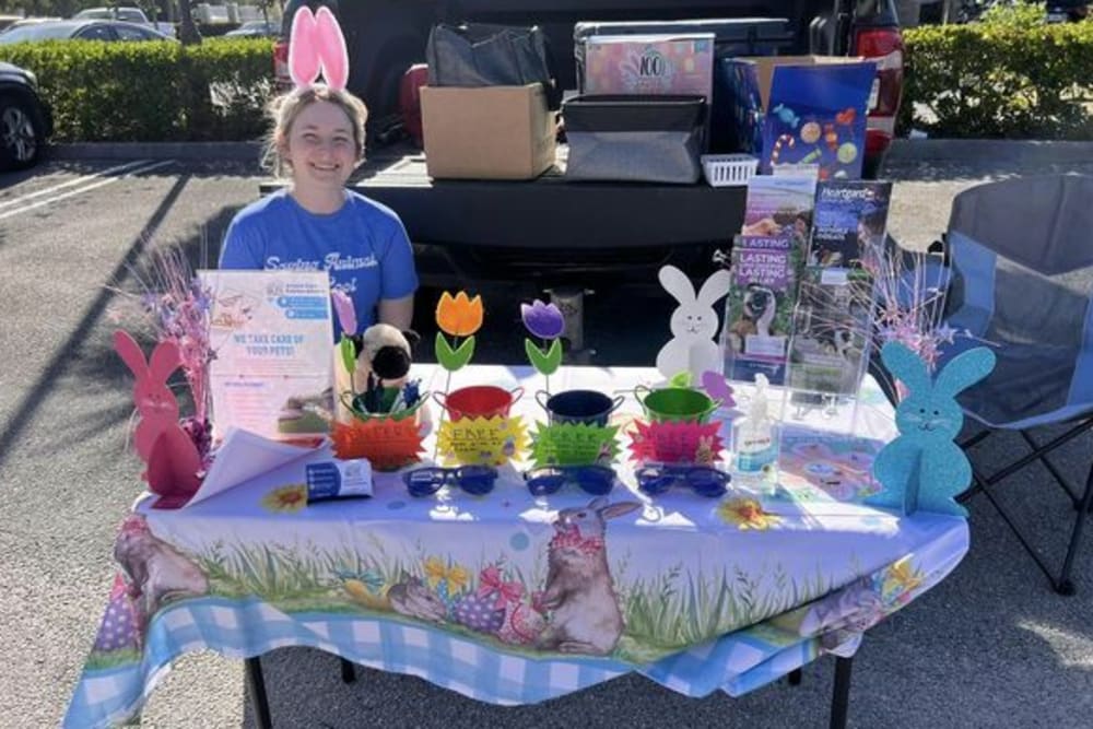 Animal Care Extraordinaire team member sitting at table behind pickup truck at Texas Roadhouse's First Annual Trunk Hop